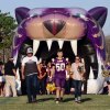 Senior Carlos Munoz (No. 50) walks with his parents through the Tiger's mouth.